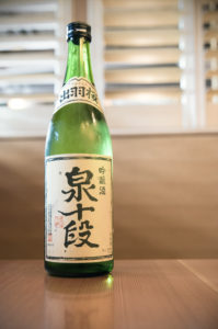 a bottle of Izumi Judan from Dewazakura on a wood table